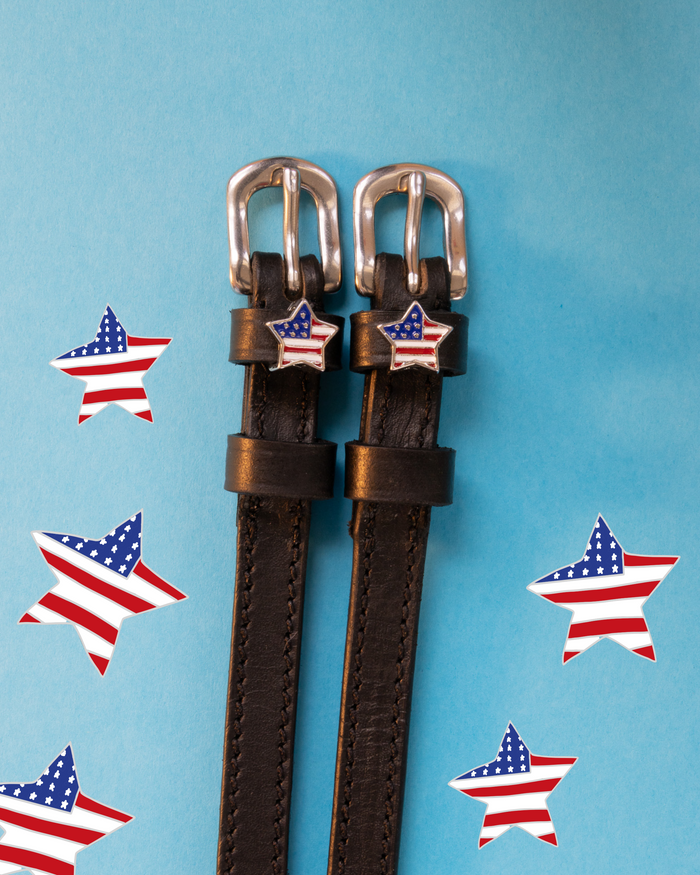 Brown leather ManeJane spur straps with silver buckles and American-flag star charms