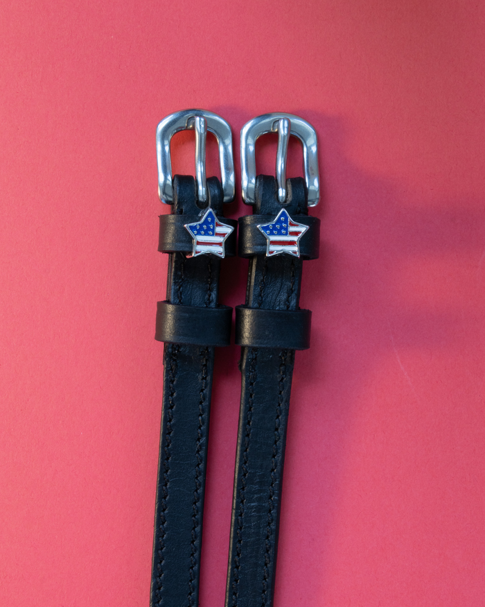 Pair of black leather American star spur straps with silver buckles on coral