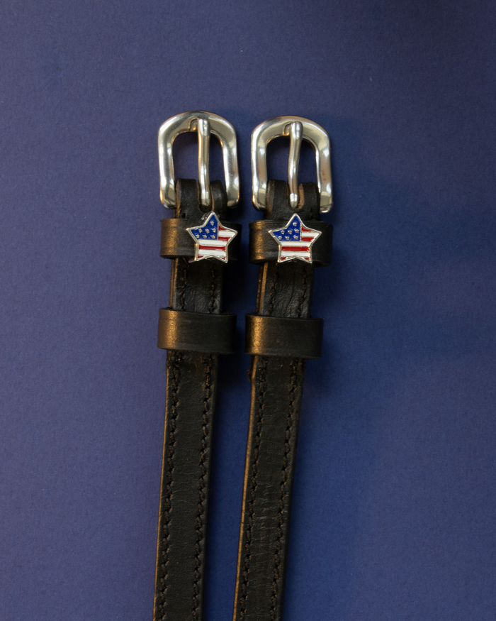 Brown leather American-flag star spur straps with silver buckles on indigo