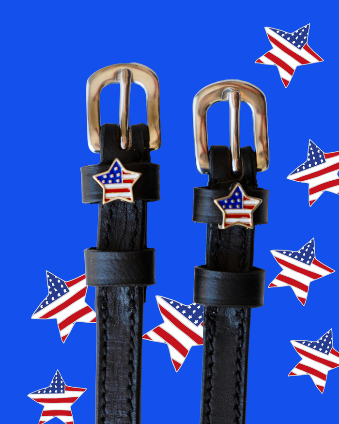 Black leather American star spur straps with brass buckles on a bright blue backdrop