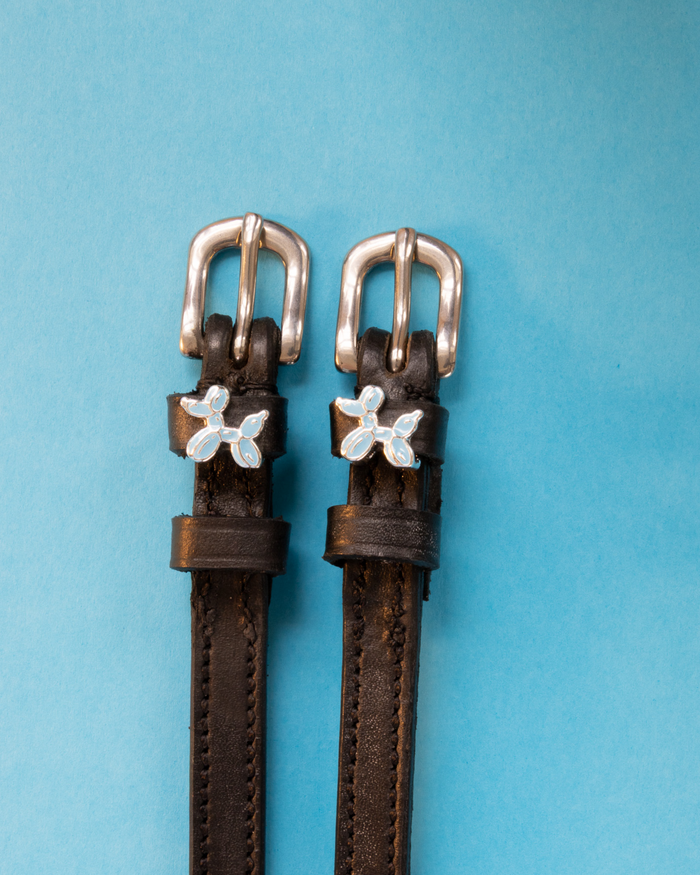 Dark brown leather balloon dog spur straps on a light blue background