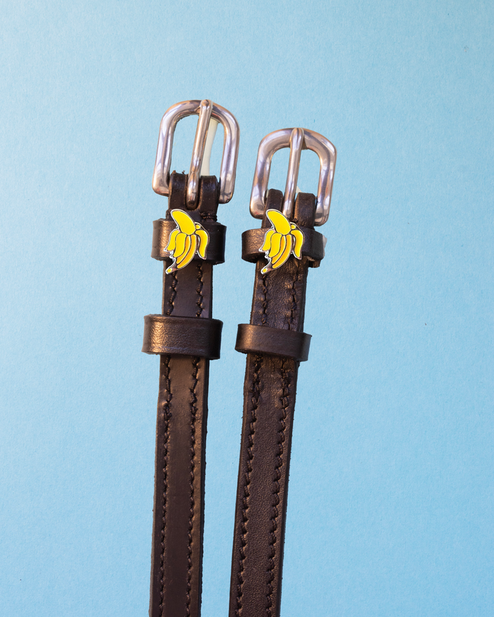 Dark brown Banana spur straps with silver buckles and banana charms on light blue