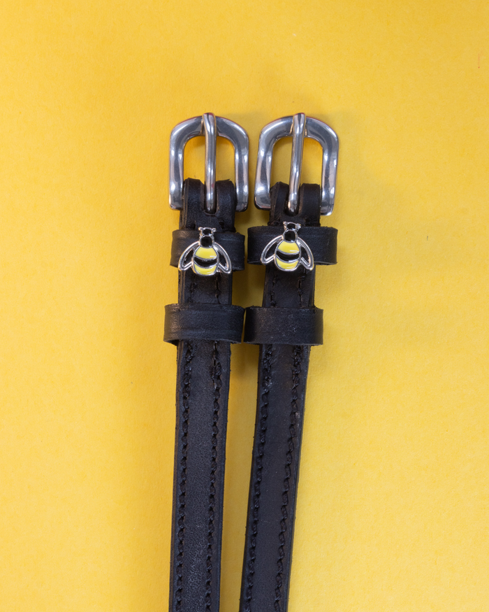Black leather ManeJane bee spur straps with silver buckles and enamel bumblebee charms on yellow