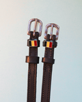 Dark brown ManeJane spur straps with Belgian flag charms on pale blue