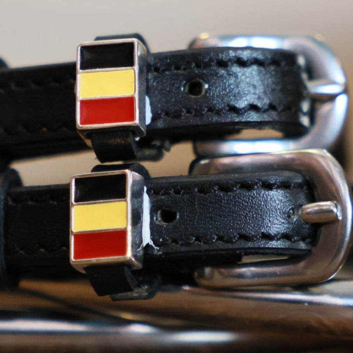 Close-up of black-yellow-red Belgian flag charms on black leather spur straps