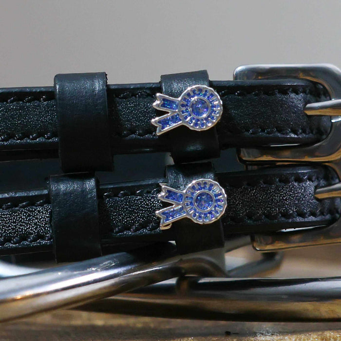 Close-up of blue rosette ribbon charms on black leather spur strap keepers