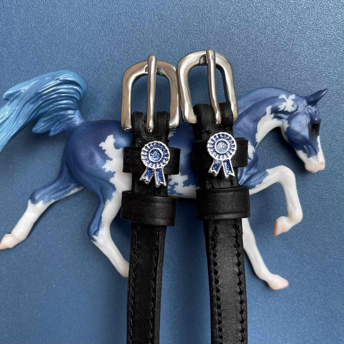 Blue rosette spur straps posed with a blue model horse figurine