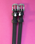 Black leather ManeJane Bunny Hop spur straps with white bunny charms on a hot pink background