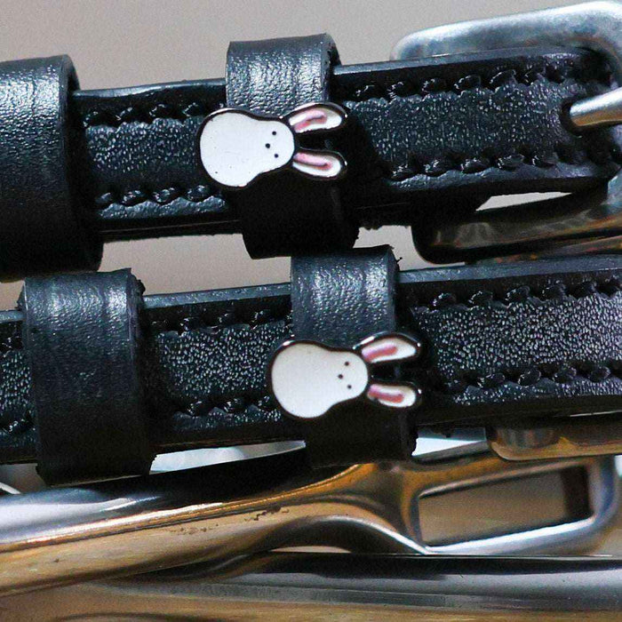 Close-up of white bunny face charms on black leather Bunny Hop spur straps, ManeJane
