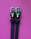 Black leather ManeJane spur straps with green potted cactus charms on a magenta background