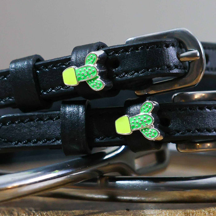 Close-up of potted cactus charms on black leather ManeJane spur strap keepers