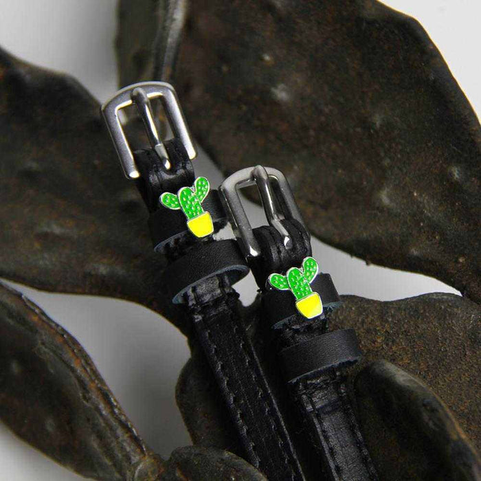 Green cactus charm ManeJane spur straps styled over dark dried seed pods