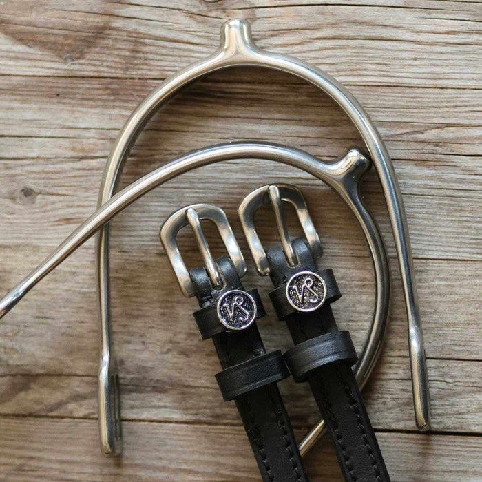 Capricorn charm spur straps flat-laid with a silver spur on weathered wood