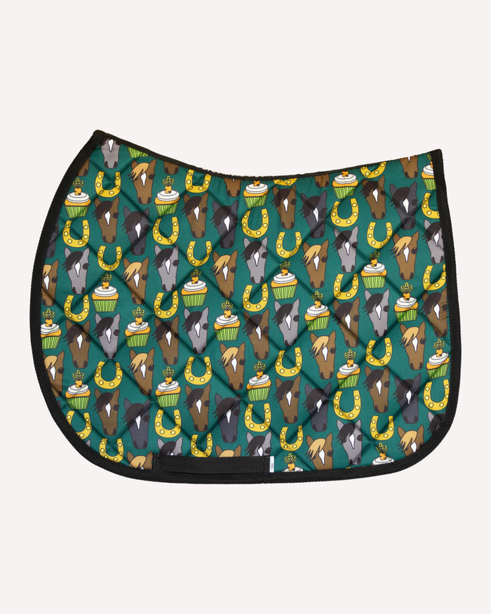 Carrot Cake saddle pad in teal with horse faces, cupcakes and horseshoes, English pad shown flat by Dreamers & Schemers