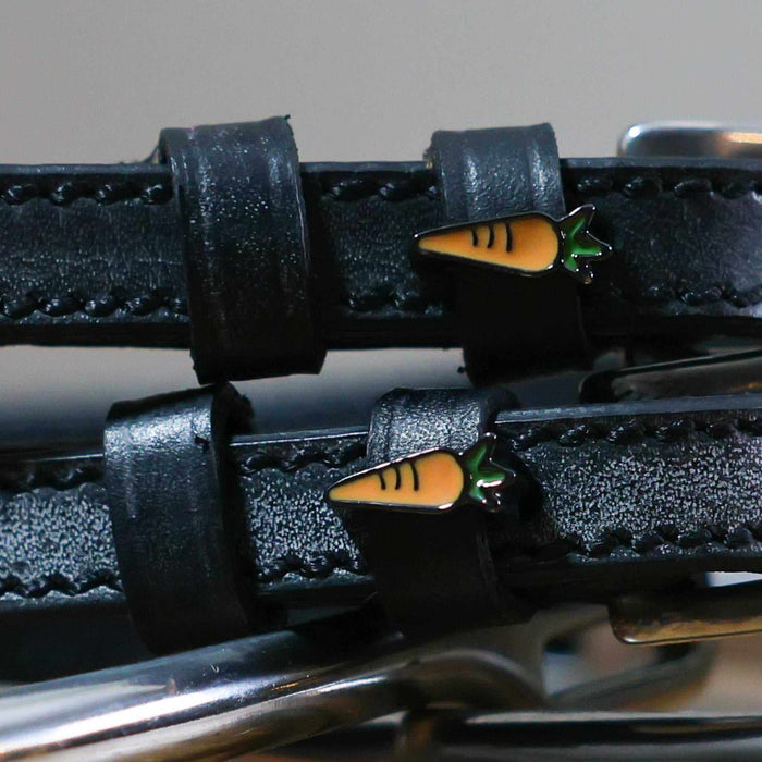 Close-up of orange carrot charms on the keepers of black leather ManeJane spur straps