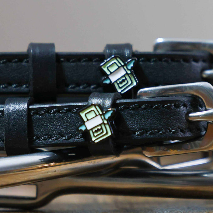 Close-up of a winged stack-of-cash charm on a black leather spur strap
