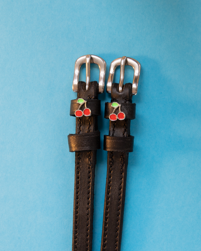 Cherry charm spur straps on a colorful ice-cream-print patterned background