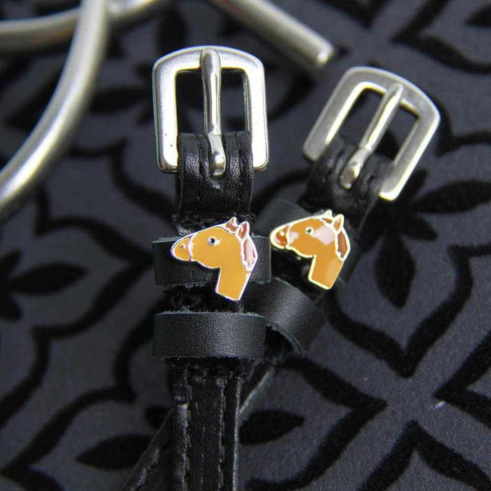 Chestnut horse-head charms and silver buckles on black spur straps, black print