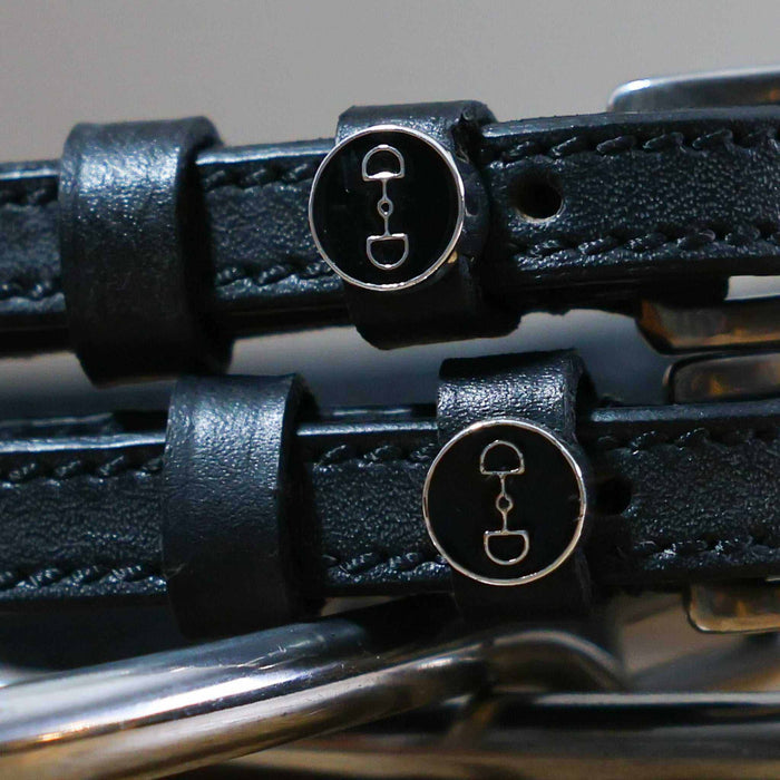 Close-up of black enamel D-ring bit charms on leather spur strap keepers