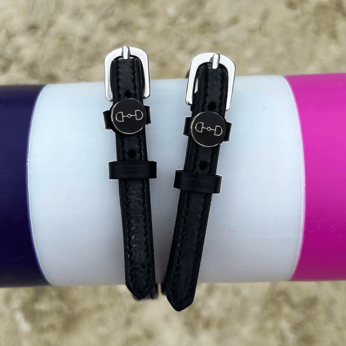 ManeJane D-ring spur straps wrapped around a white bottle outdoors