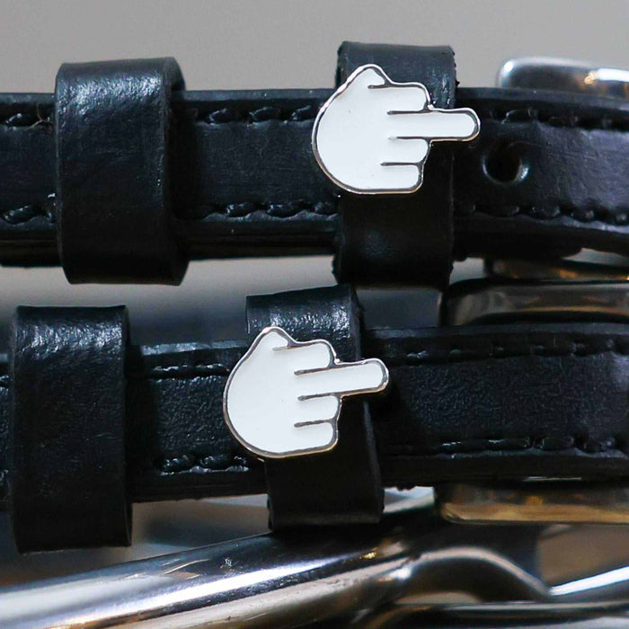 Close-up of white middle-finger emoji charms on black leather ManeJane Da Bird spur strap keepers