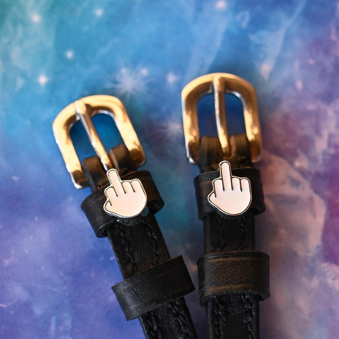 ManeJane Da Bird spur straps with brass buckles and emoji charms on a cosmic galaxy background
