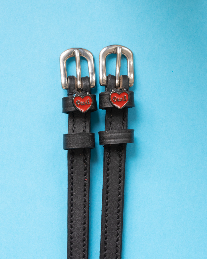 Black leather ManeJane spur straps with red Devil heart charms on light blue