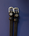 Black leather ManeJane spur straps with sparkling disco ball charms on a navy background