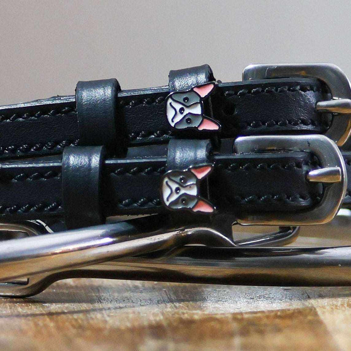 Close-up of French bulldog face charms on black leather spur strap keepers