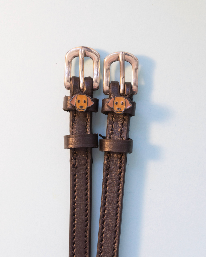 Brown leather ManeJane spur straps with silver buckles and golden Labrador dog face charms