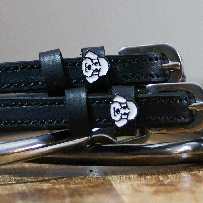 Close-up of white poodle face charms on black leather spur strap keepers