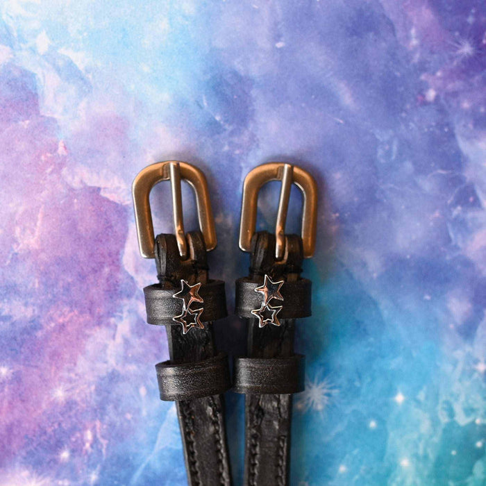 Black leather double star spur straps with brass buckles on a galaxy backdrop