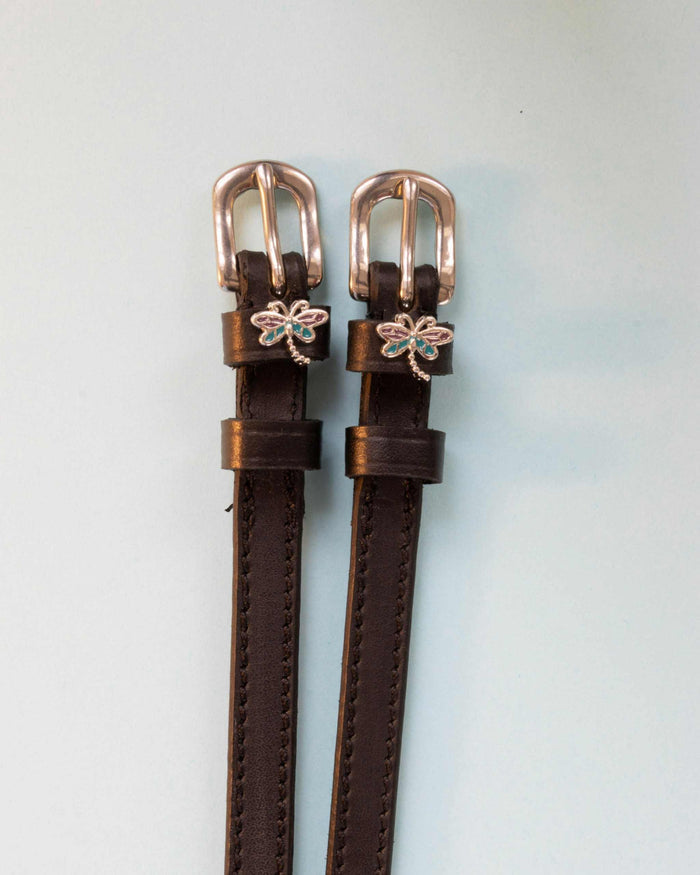 Dragonfly ManeJane spur straps with the signature Dragonfly charm, shown on an off-white background