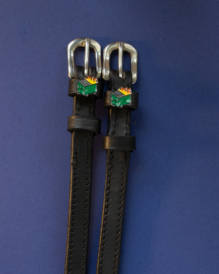 Black leather dumpster fire spur straps with silver buckles on navy blue
