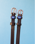 Brown leather ManeJane spur straps with silver buckles and blue evil eye charms