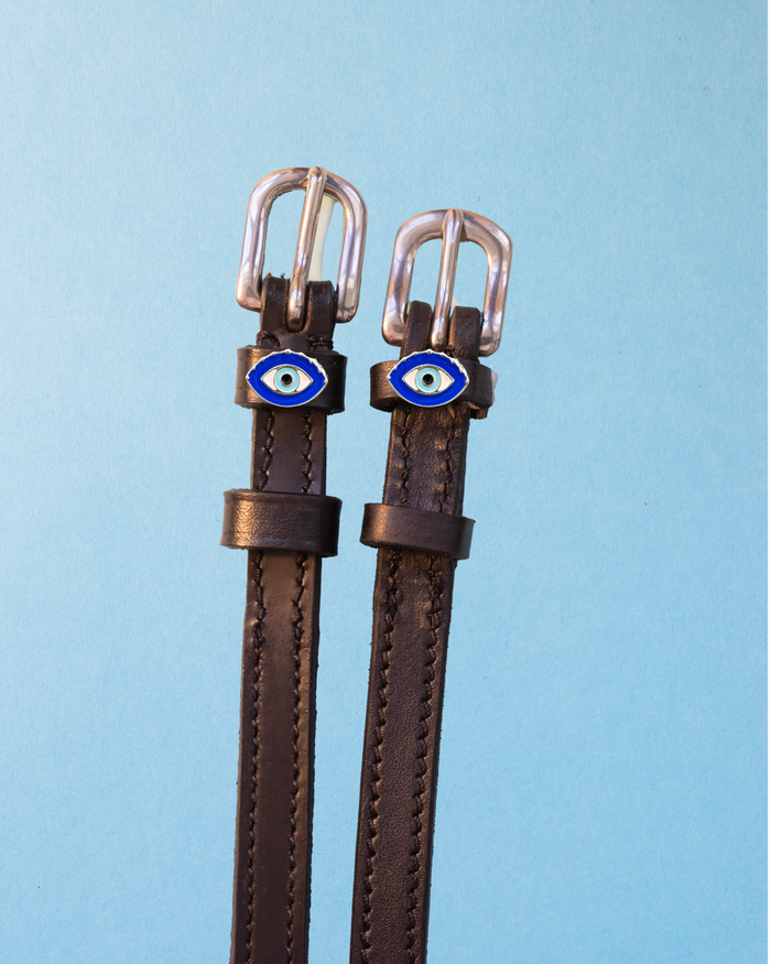 Brown leather ManeJane spur straps with silver buckles and blue evil eye charms