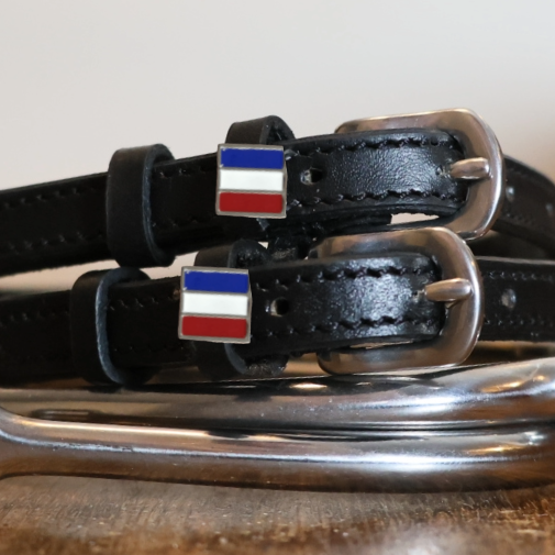 Close-up of enamel French tricolor flag charms on black leather spur strap keepers