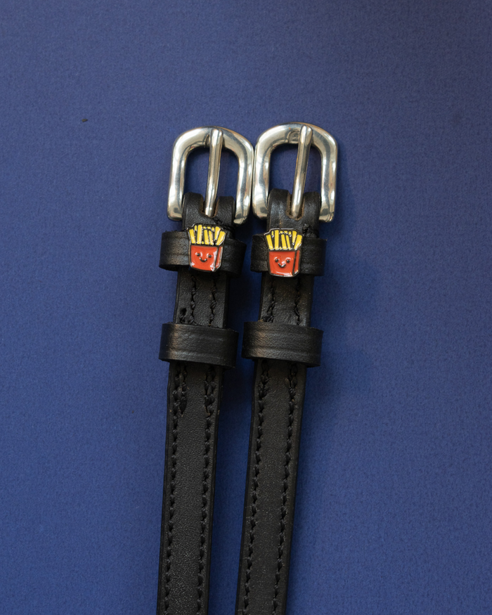 Pair of black leather French Fries spur straps with silver buckles on a navy background