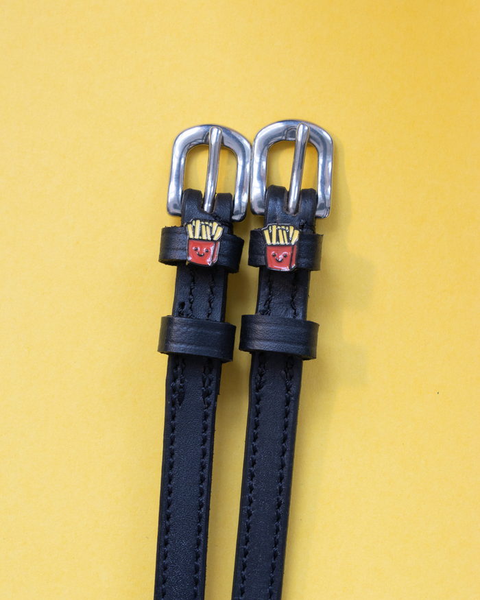 Black leather French Fries spur straps with silver buckles and fry charms on yellow