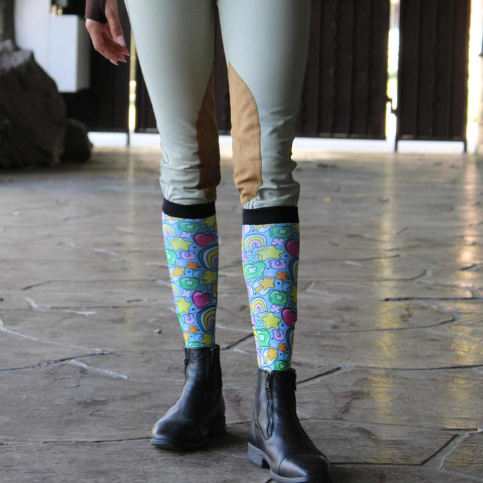 Youth equestrian wearing colorful Lucky Equestrian Bundle socks with riding boots and beige riding pants
