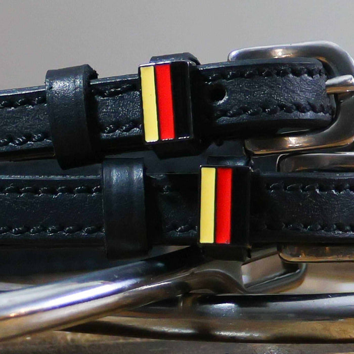 Close-up of black-red-gold German flag charms on black leather spur strap keepers