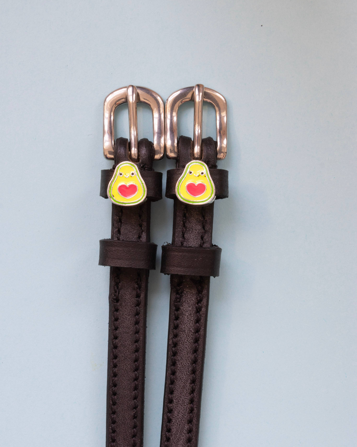 Brown leather avocado spur straps with rose-gold buckles and heart-pit charms