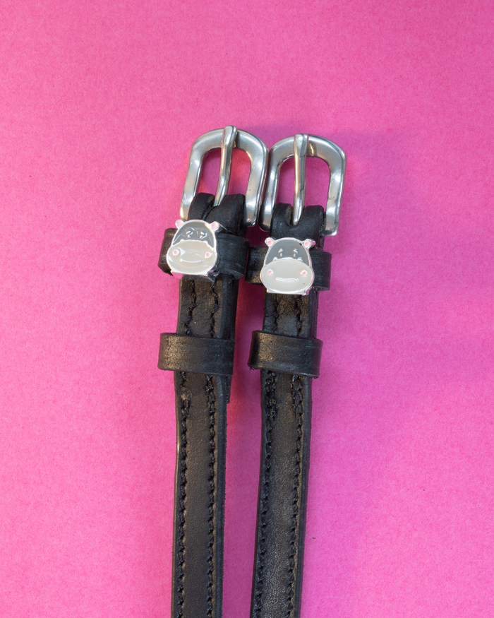 Black leather ManeJane Hippo Face spur straps with silver buckles and hippo charms on pink