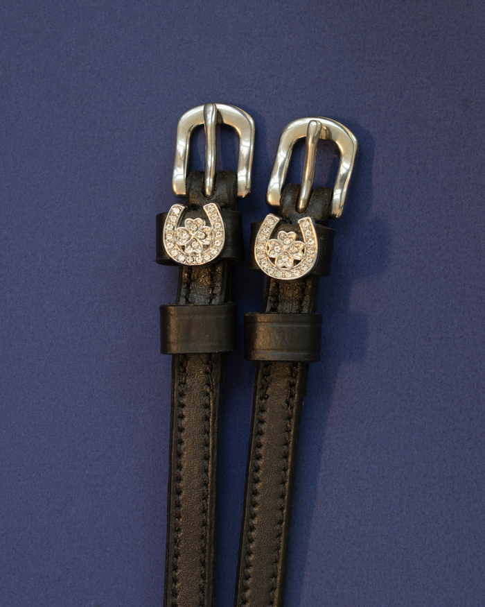 Black leather ManeJane spur straps with crystal horseshoe and clover charms on navy
