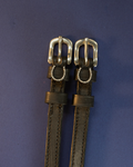 Black leather ManeJane spur straps with silver buckles and crystal horseshoe charms on navy