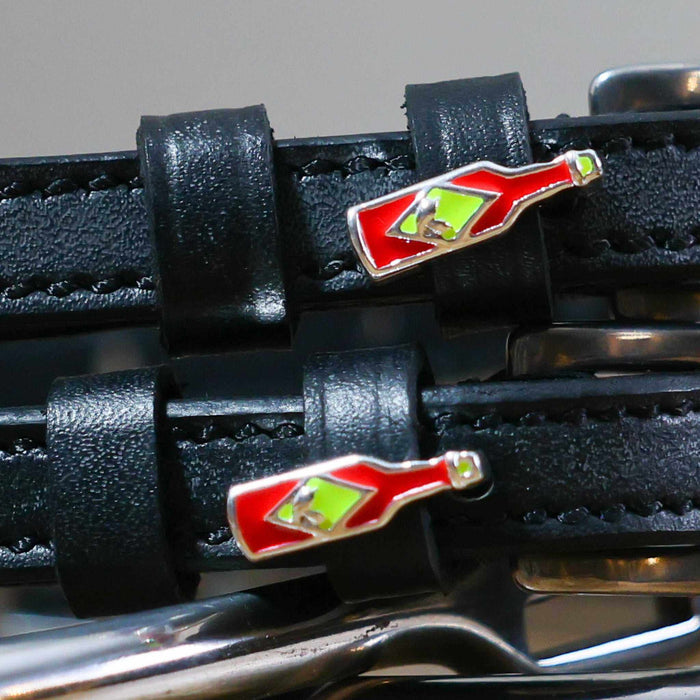 Close-up of red hot sauce bottle charms on black leather spur strap keepers