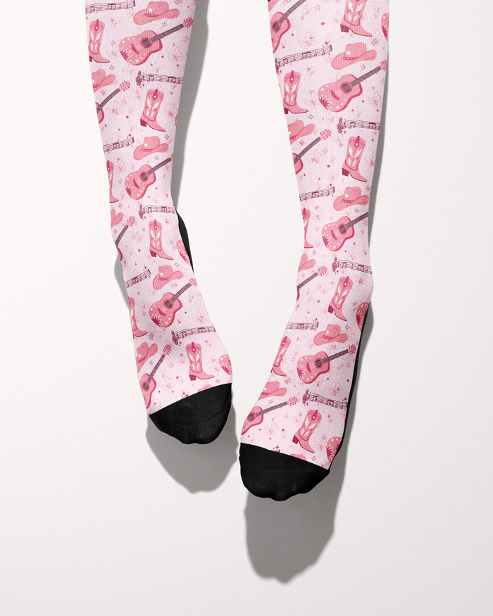 Dolly Forever socks shown on bare feet with black toes, pink cowgirl-themed print
