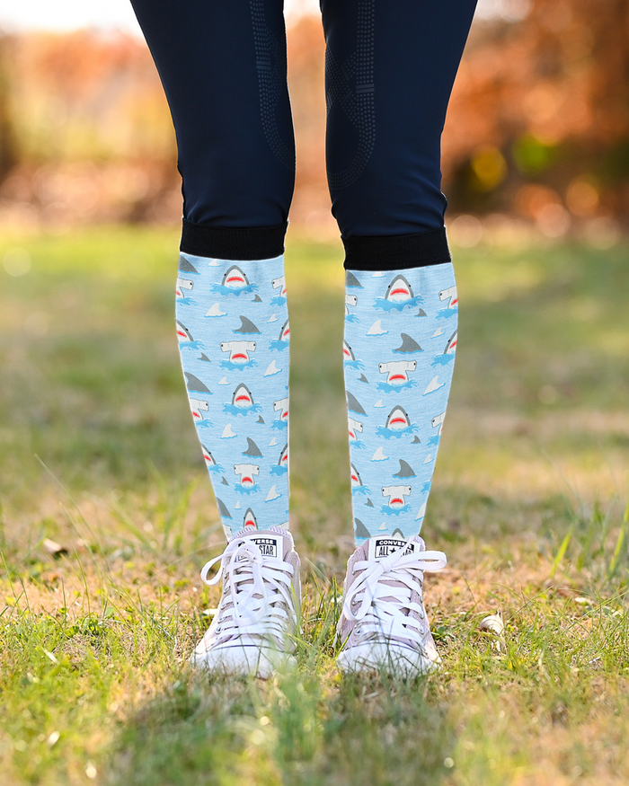 Shark Week equestrian boot socks worn pulled up to mid-calf with navy breeches and white sneakers