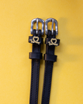 Black leather ManeJane Long Dogs spur straps with gold dachshund-heart charms on yellow