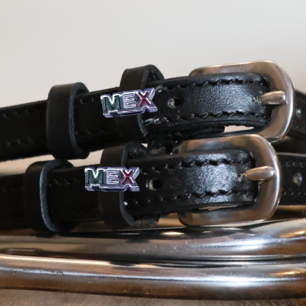 Close-up of MEX lettering charms on black leather spur straps over a silver spur